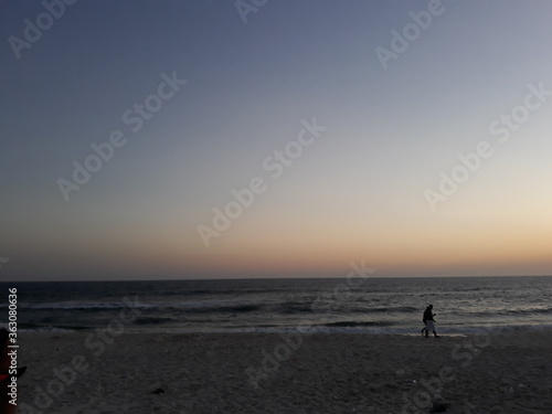 man walking on the beach at sunset