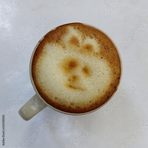cup of coffee with latte art teddy bear on white background.