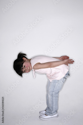 Girl bending down, hands by her side