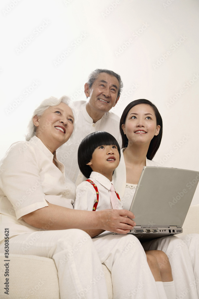 Boy and woman together with senior couple smiling while looking up Boy and woman together with senior couple smiling while looking up