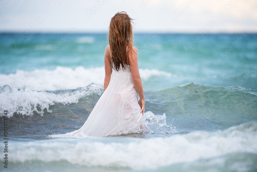 Young woman in nature with beautiful sea and blue sky. Summer vacation and travel concept. Dream and imagination. Sensual girl playing with Waves on blue sea. Young woman in nature with beautiful sea and blue sky. Summer vacation and travel concept. Dream and imagination. Sensual girl playing with Waves on blue sea.