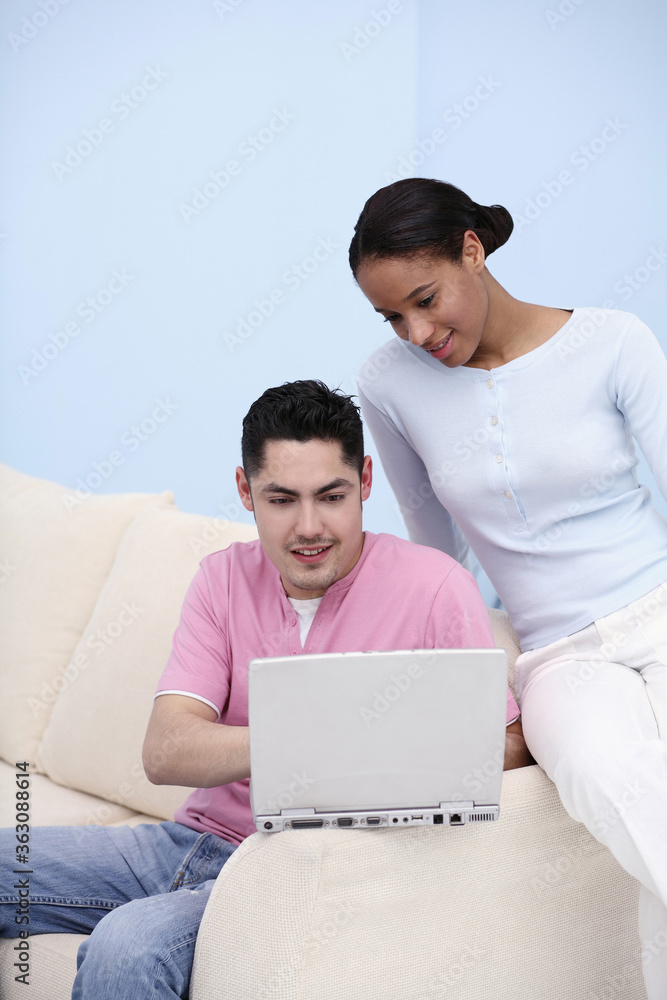 Man using laptop, woman watching Man using laptop, woman watching