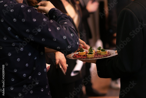People mingle with canapes