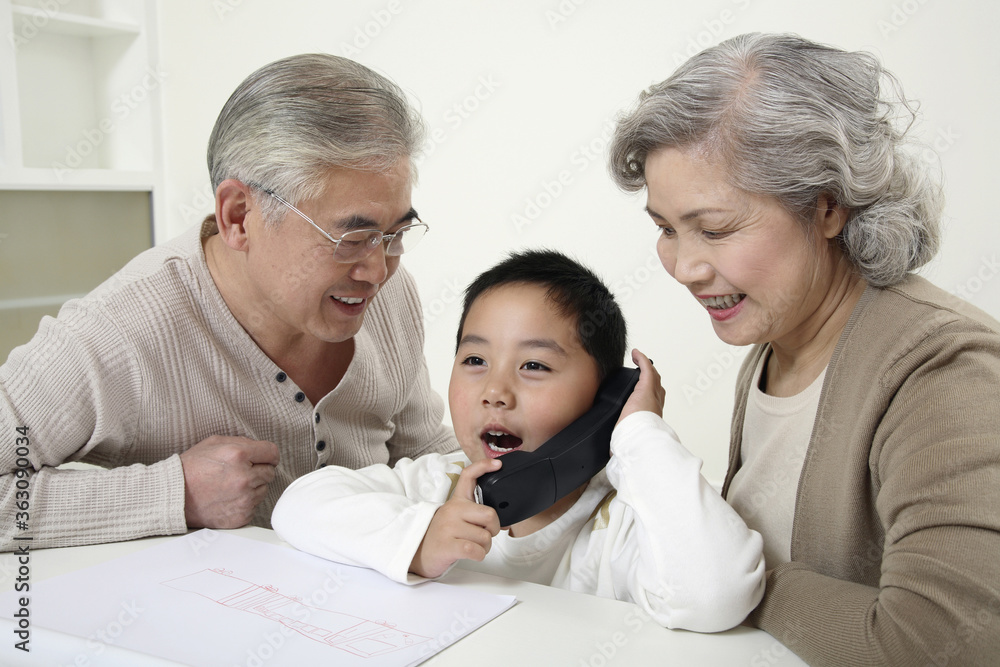 Boy talking on the phone, senior couple watching Boy talking on the phone, senior couple watching
