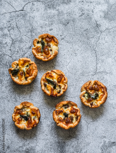 Minced meat, spinach, mozzarella cheese mini pies for appetizers, tapas on a gray background, top view