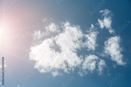 Blue sky with white clouds and sun. Beautiful natural background. 