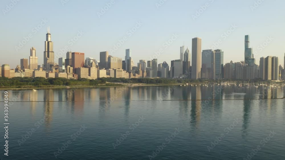 Drone Flies Towards Chicago Skyline over Lake Michigan, Cityscape Reflection in Water on Summer Day Drone Flies Towards Chicago Skyline over Lake Michigan, Cityscape Reflection in Water on Summer Day