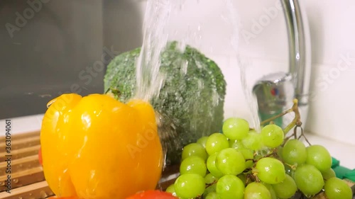 Washing fresh fruits in the sink in slow motion photo