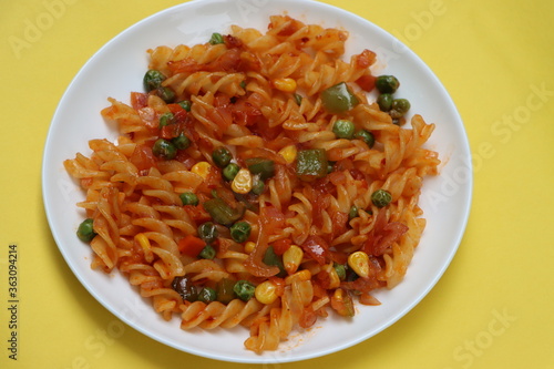Red fusillli pasta with vegetables, corn, peas, red sauce
