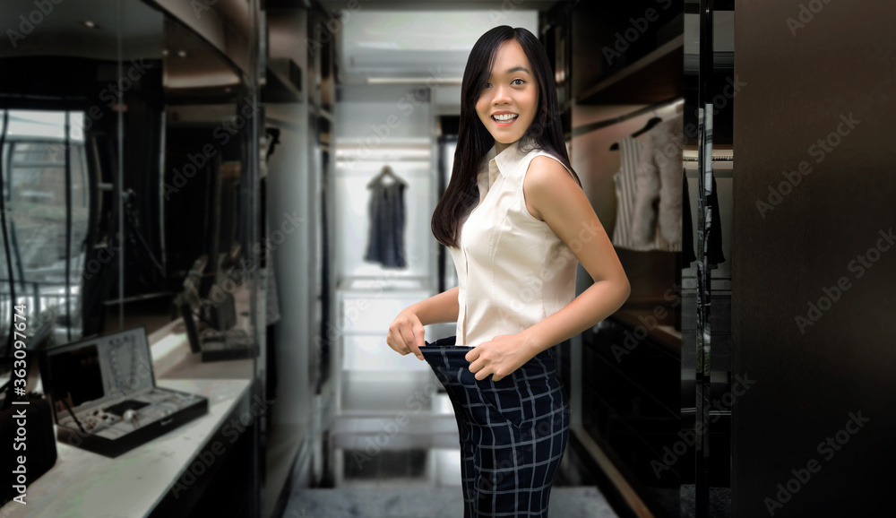 happy asian woman loss weight fitting dress in walk in clothes happy asian woman loss weight fitting dress in walk in clothes