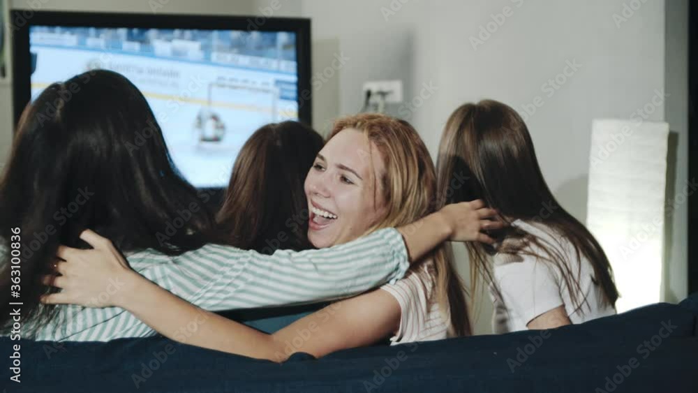 Excited millenials cheering for team sitting in living room. Backshot group of teens watching hockey match on tv celebrating goal. Concept of leisure, lifestyle, spending time together, victory. Excited millenials cheering for team sitting in living room. Backshot group of teens watching hockey match on tv celebrating goal. Concept of leisure, lifestyle, spending time together, victory.