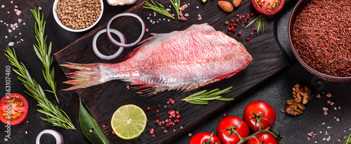 Fotografie Raw fillet of red sea perch prepared for baking with spices and herbs