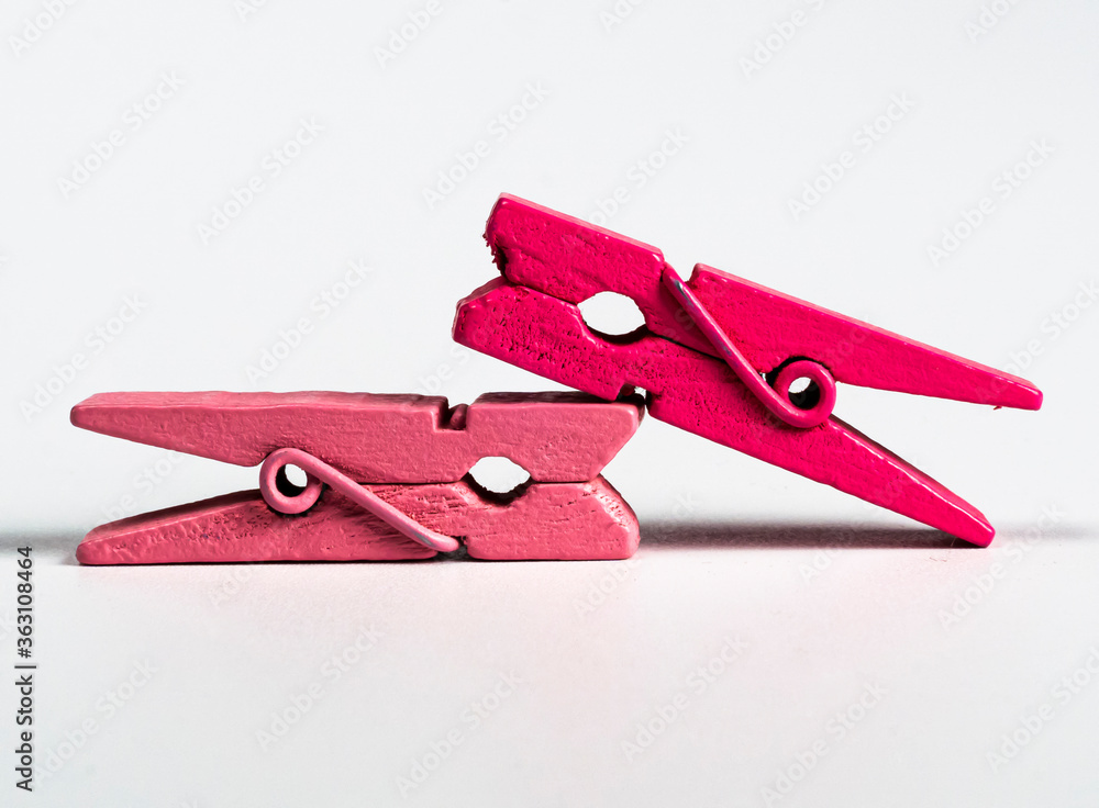 two pink wooden board clips are kept one top of other for decoration on isolated white background two pink wooden board clips are kept one top of other for decoration on isolated white background