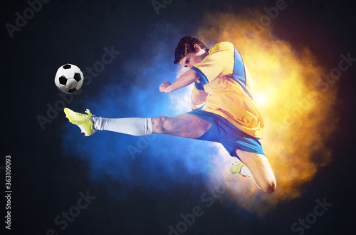Soccer player kicking ball in colorful smoke