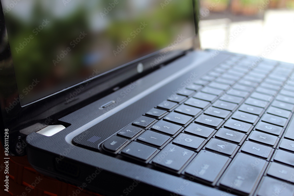 Partial display of laptop and work from home background. Key board display with selective focus. Partial display of laptop and work from home background. Key board display with selective focus.