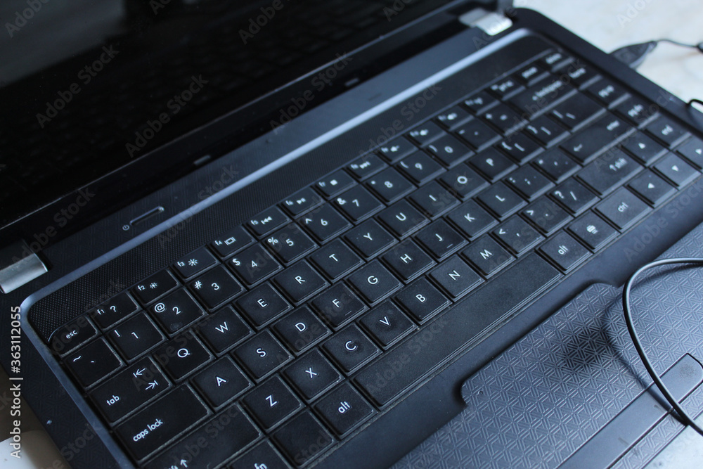 Partial display of laptop and work from home background. Key board display with selective focus. Partial display of laptop and work from home background. Key board display with selective focus.