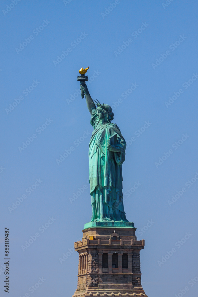 Obraz premium Close shot of Statue of Liberty in New York City, with blue sky.