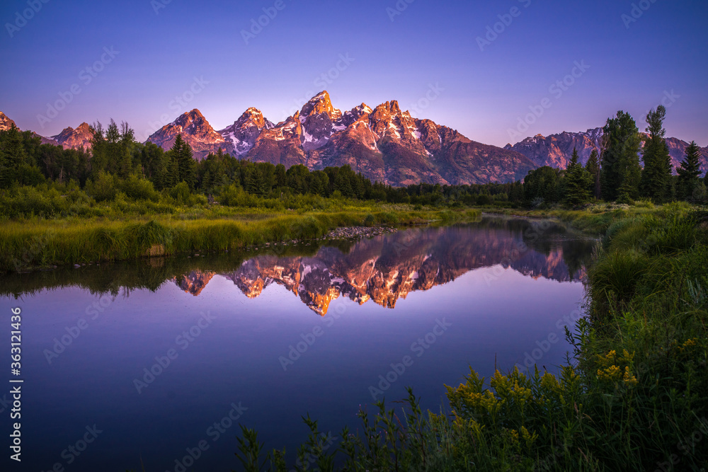 The sunrise view of Mount Grand Teton, with reflection in front.