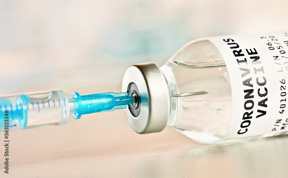 Coronavirus covid-19 vaccine concept - glass bottle with silver cap hypodermic syringe needle injected, closeup detail (sticker is own design - not real product) Coronavirus covid-19 vaccine concept - glass bottle with silver cap hypodermic syringe needle injected, closeup detail (sticker is own design - not real product)