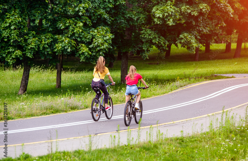 Cyclists ride on the bike path in the city Park