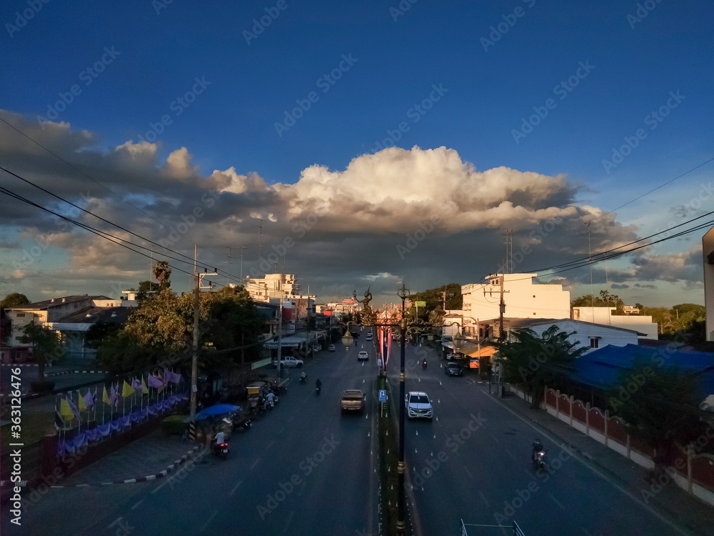 view evening of dark clouds moving above street and many buildings with blue sky background.