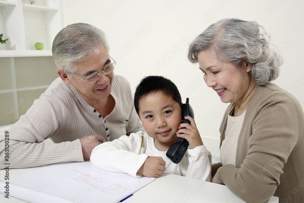 Boy talking on the phone, senior couple watching Boy talking on the phone, senior couple watching