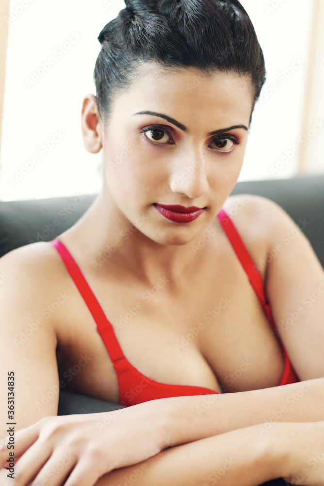 A lady in red bra sitting on a black couch A lady in red bra sitting on a black couch