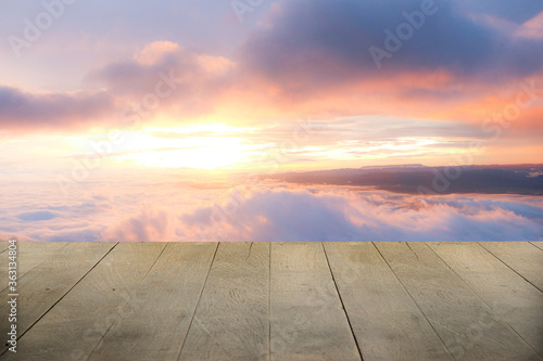 Wooden terrace with space for placing items or advertising media. There is a sunrise background in the morning.