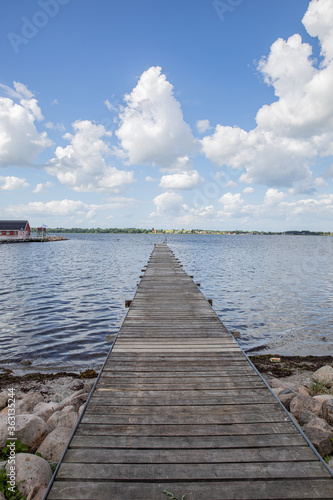 Wallpaper Mural old bridge going out into the water with blue sky and clouds  Torontodigital.ca