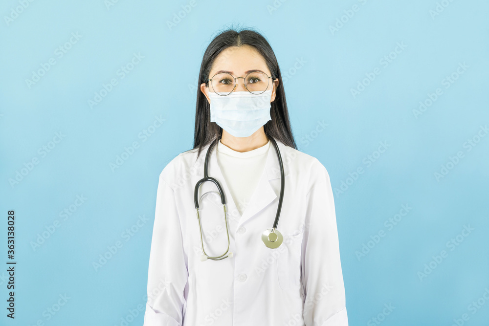 Smart young asian woman doctor in lab coat with Medical face mask,white latex medical gloves and stethoscope against blue background,health care concept Smart young asian woman doctor in lab coat with Medical face mask,white latex medical gloves and stethoscope against blue background,health care concept