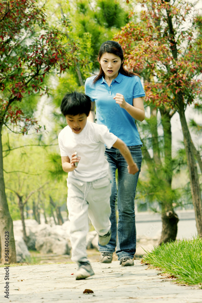A woman chasing after a young boy
