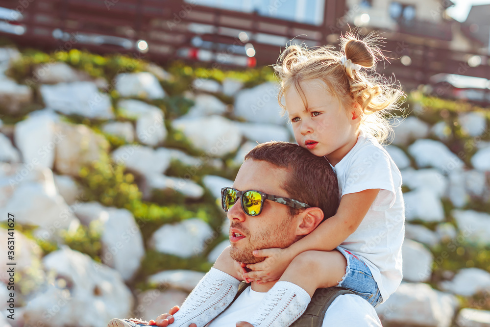 Obraz premium the child is sitting on the neck of the father