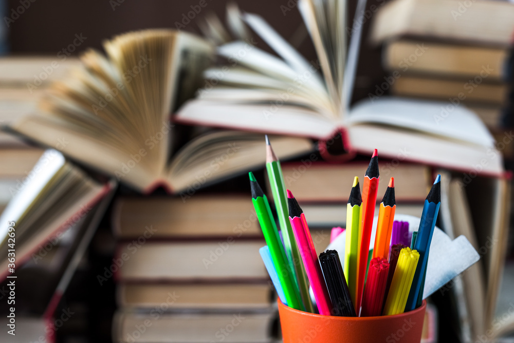 A stack of books and pencils on a desk in elementary school. A stack of colorful books. Education background. Business education concept. Copy space for text. A stack of books and pencils on a desk in elementary school. A stack of colorful books. Education background. Business education concept. Copy space for text.