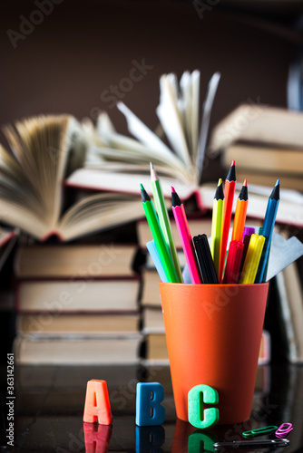 A stack of books and pencils on a desk in elementary school. A stack of colorful books. Education background. Business education concept. Copy space for text.