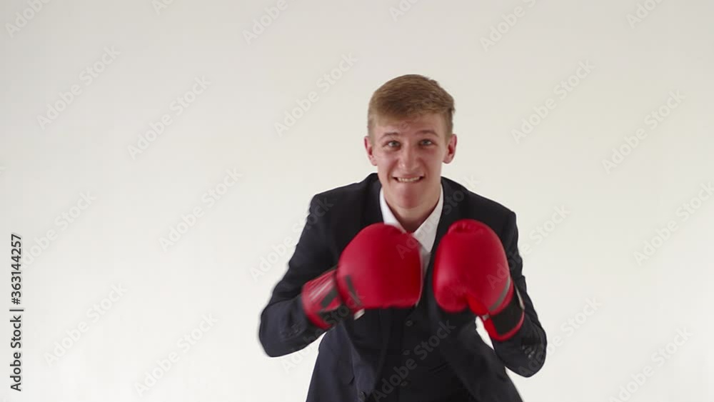 An angry, aggressive businessman with boxing gloves says that you cannot challenge him in boxing or in business. Workplace stress resistance concept, office worker An angry, aggressive businessman with boxing gloves says that you cannot challenge him in boxing or in business. Workplace stress resistance concept, office worker