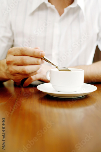 Man stirring a cup of coffee