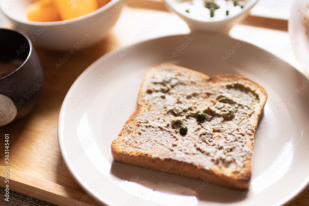Chicken liver pate on bread with iced coffee, mango and soft boiled egg with seasoning sauce and ground pepper on wooden tray. Easy healthy breakfasts for your morning. Chicken liver pate on bread with iced coffee, mango and soft boiled egg with seasoning sauce and ground pepper on wooden tray. Easy healthy breakfasts for your morning.