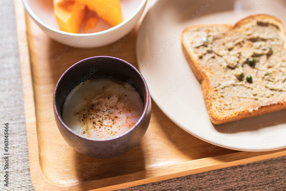 Chicken liver pate on bread with iced coffee, mango and soft boiled egg with seasoning sauce and ground pepper on wooden tray. Easy healthy breakfasts for your morning. Chicken liver pate on bread with iced coffee, mango and soft boiled egg with seasoning sauce and ground pepper on wooden tray. Easy healthy breakfasts for your morning.