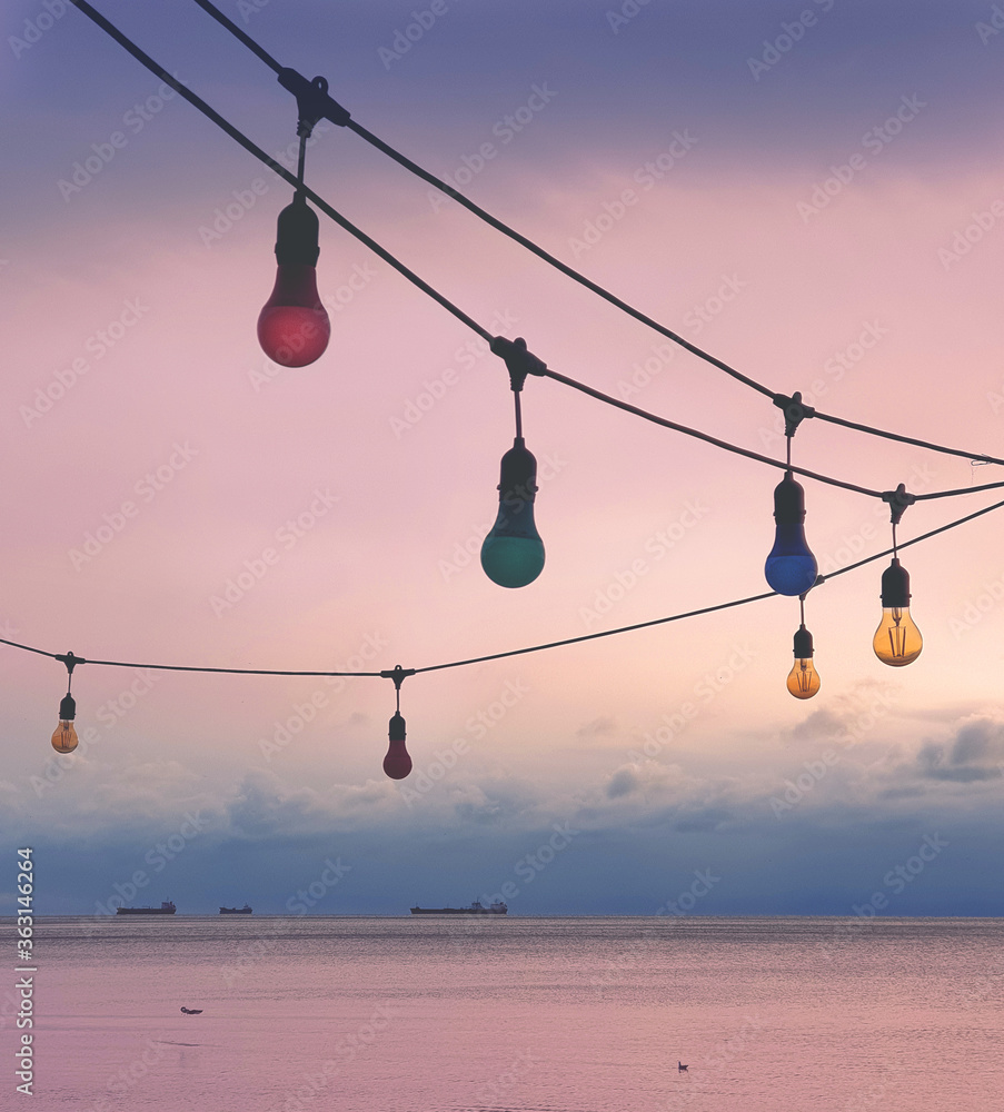 Light bulbs against sunset sky with sea view on a background. Light bulbs against sunset sky with sea view on a background.