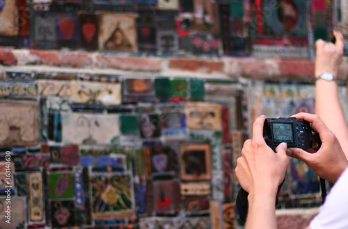 Tbilisi / Georgia - July 20 2014: Tourist make a photo of colored mosaic on the wall of the Tbilisi Theater Rezo Gabriadze.  photo