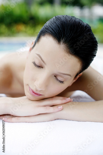 Woman lying forward on massage table with her eyes closed