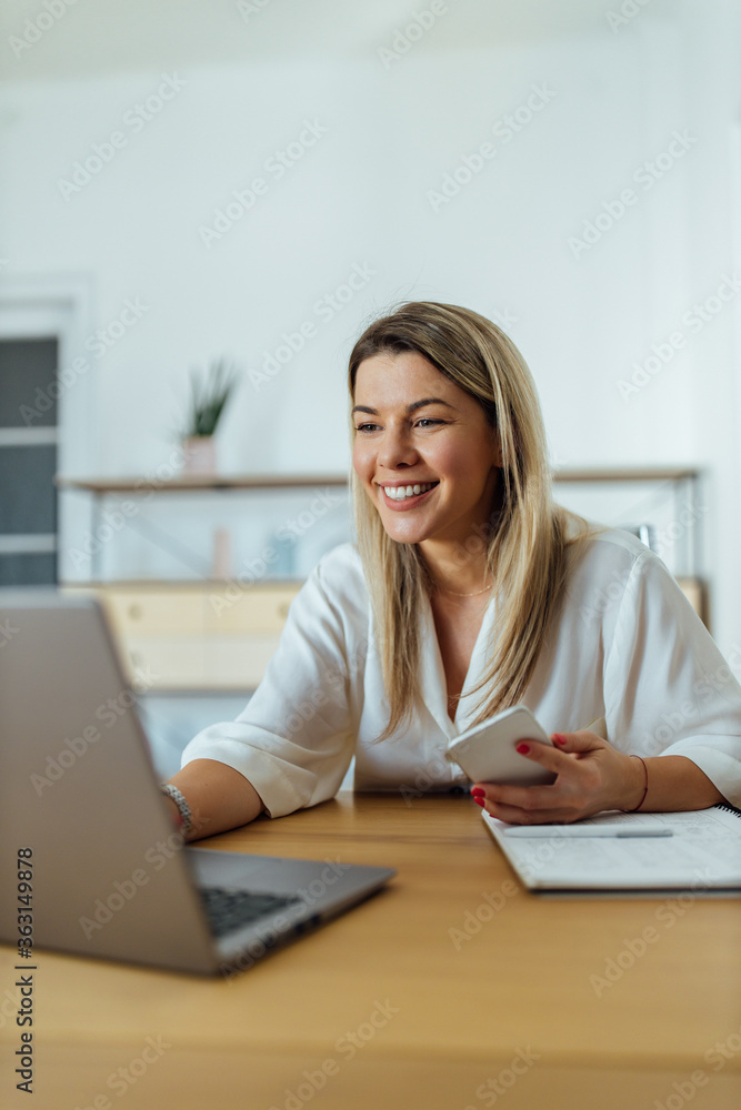 Smiling woman working on laptop in the office, portrait. Smiling woman working on laptop in the office, portrait.