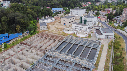 Aerial view of treatment facilities in close urban development. Engineering infrastructure in the mountains.