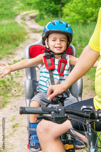 Caucasian joyful happy child have biking helmet on the bicycle.