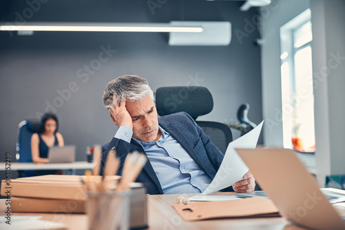 Busy businessman with document or agreement at the desk