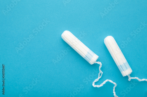 Menstrual tampons on a blue background with copy space. Cotton tampon for women