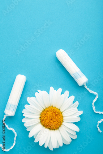 Medicinal chamomile flower and menstrual sanitary tampon. Woman critical days, gynecological menstruation cycle.