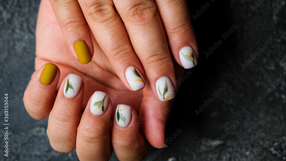 Women's hands with colorful patterns on the nails. Summer colors trend. Top view. The place for text. Women's hands with colorful patterns on the nails. Summer colors trend. Top view. The place for text.