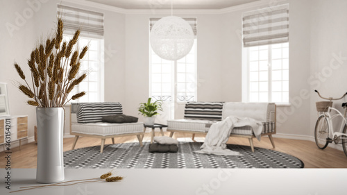 White table top or shelf with straws, dry plants, ornament, ears, sheaf, branch in vase, over white living room with sofa, armchair and carpet, parquet, modern minimal interior design