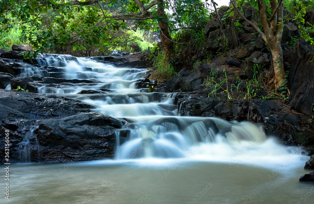 Obraz premium Stream in the rainforest with soft flowing water like wool flowing through the cliff creates a peaceful landscape to relax soul and music